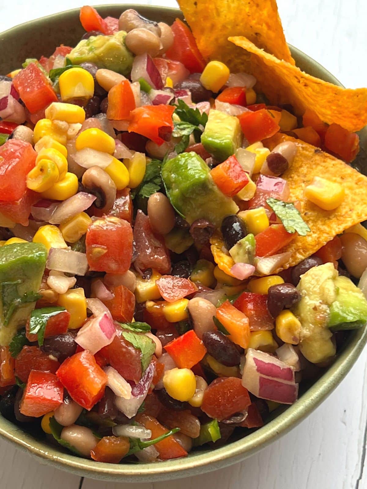 Cowboy salsa in a green bowl with nacho chips.