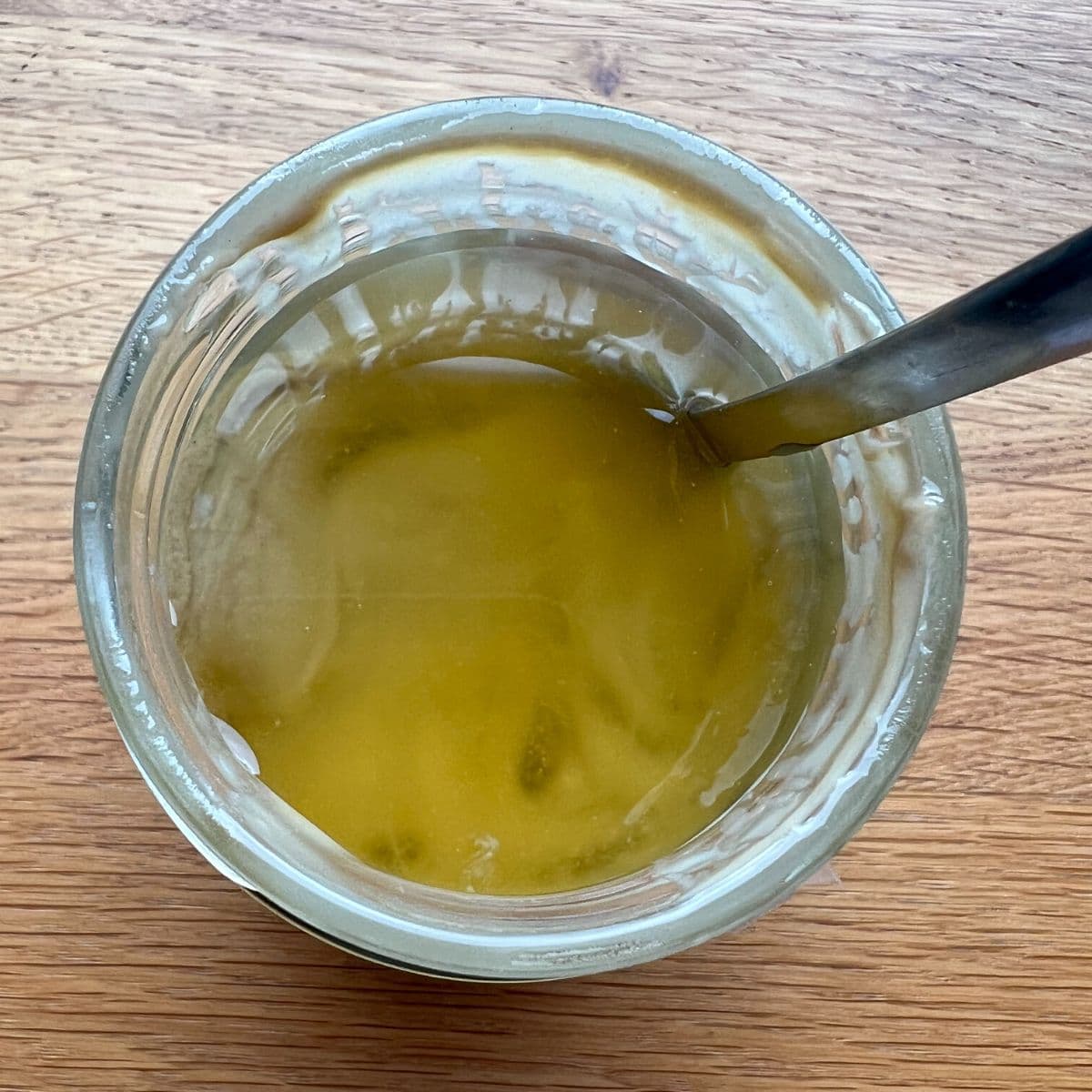 Layer of oil on tahini paste in open jar.