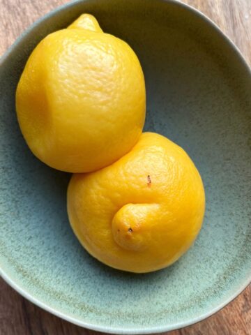 Boiled lemons in small green bowl.