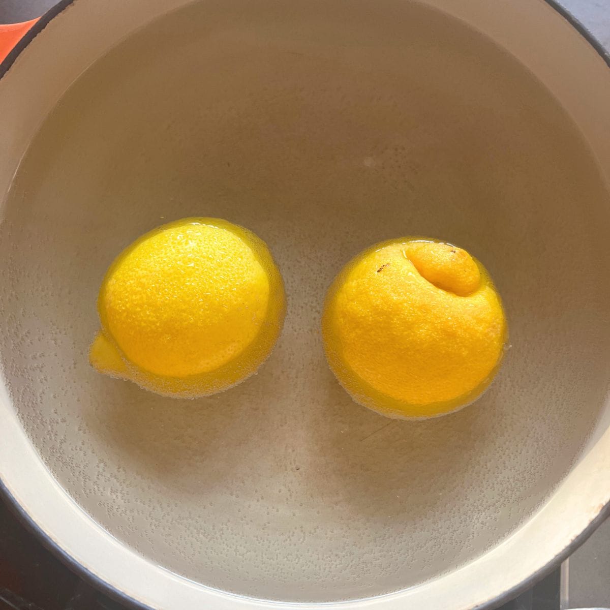 Boiling two lemons in a pan filled with water.