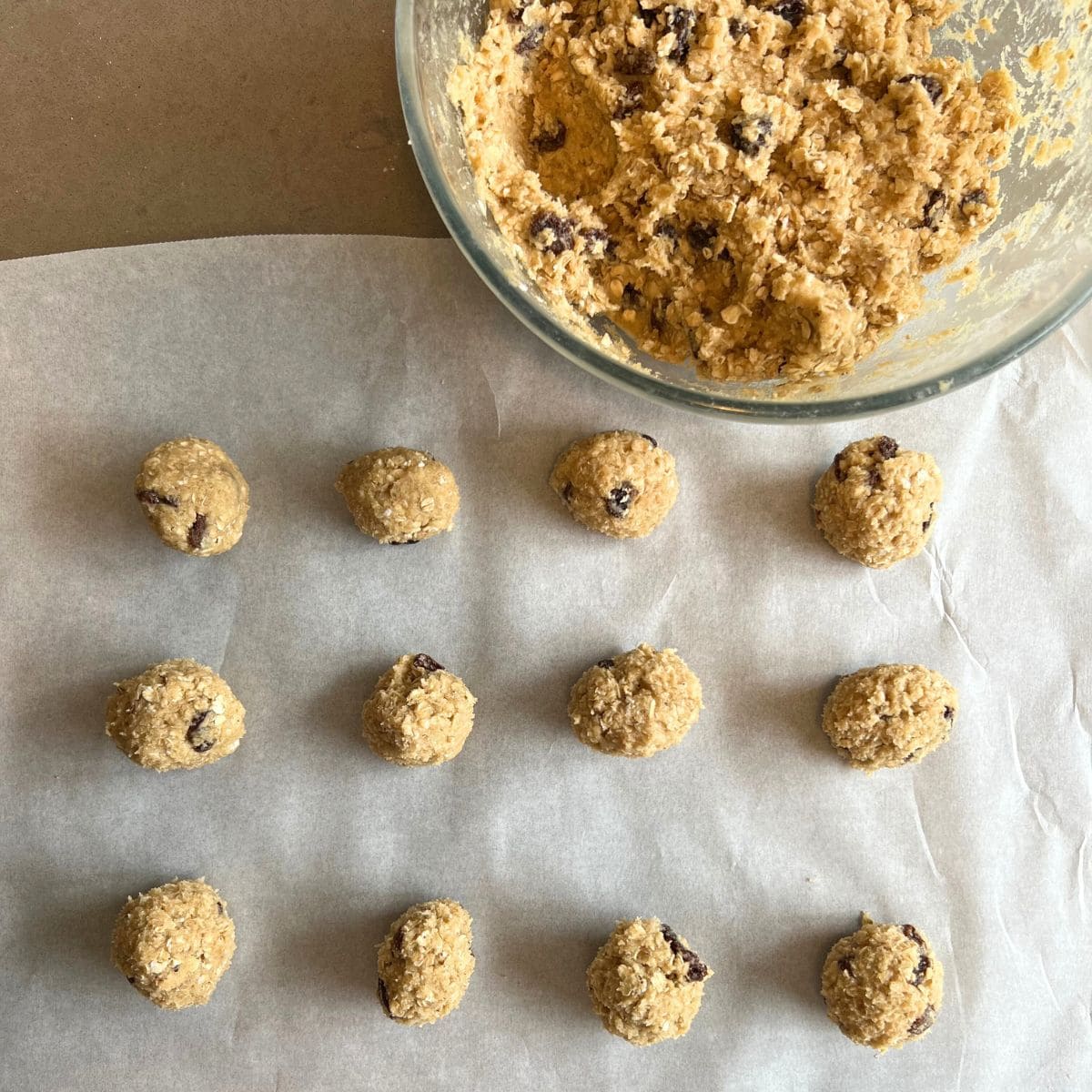 Cookie dough rolled into small balls on a lined baking sheet.
