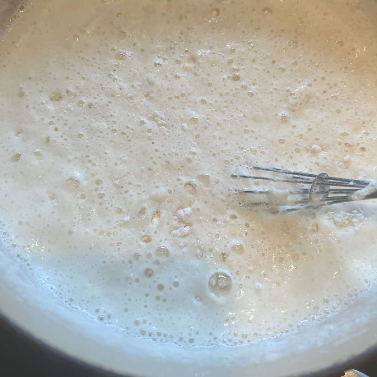 Mixing rice flour and sugar into cardamom milk.