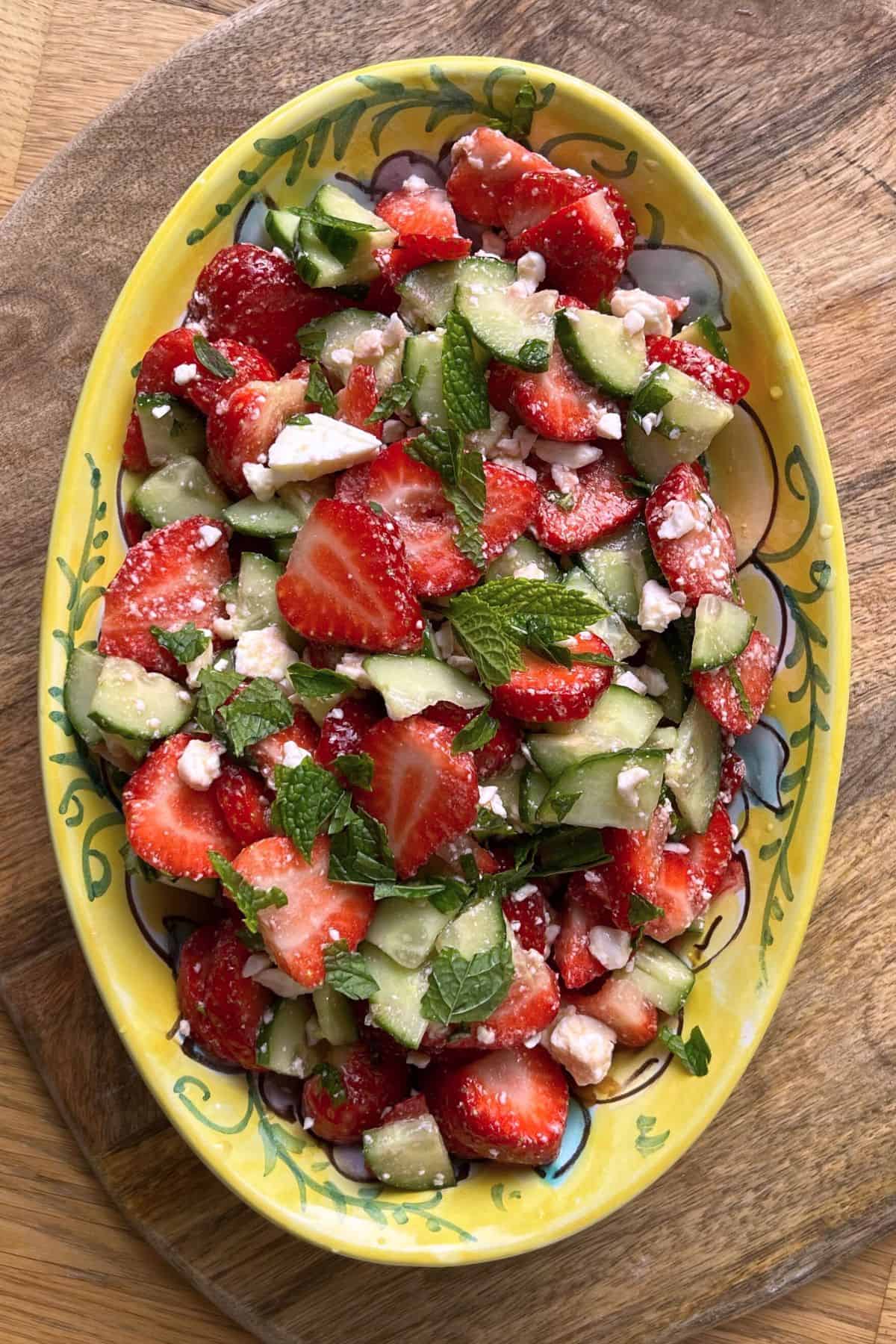 Strawberry salad in a painted oval plate.
