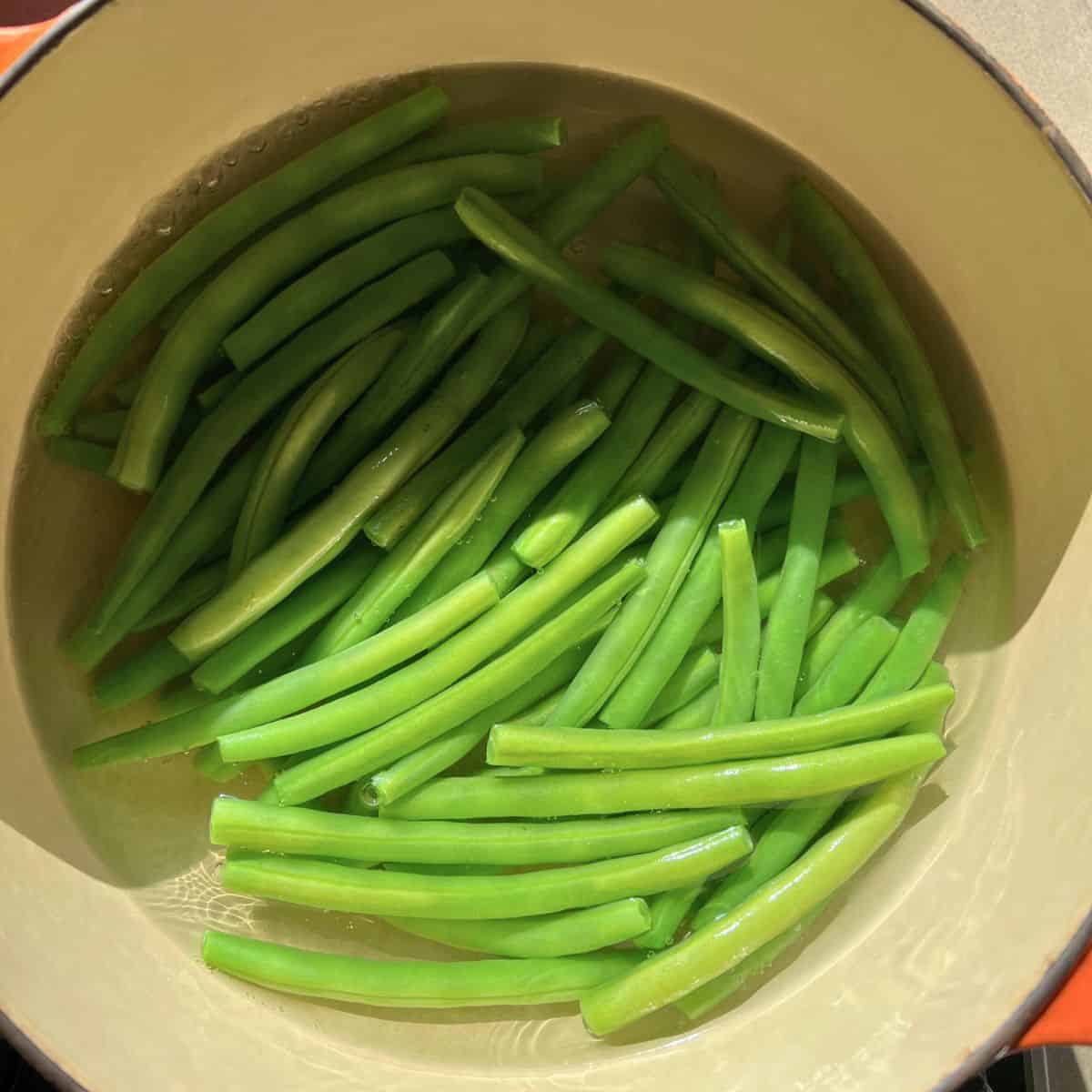 Boiling green beans in a saucepan.
