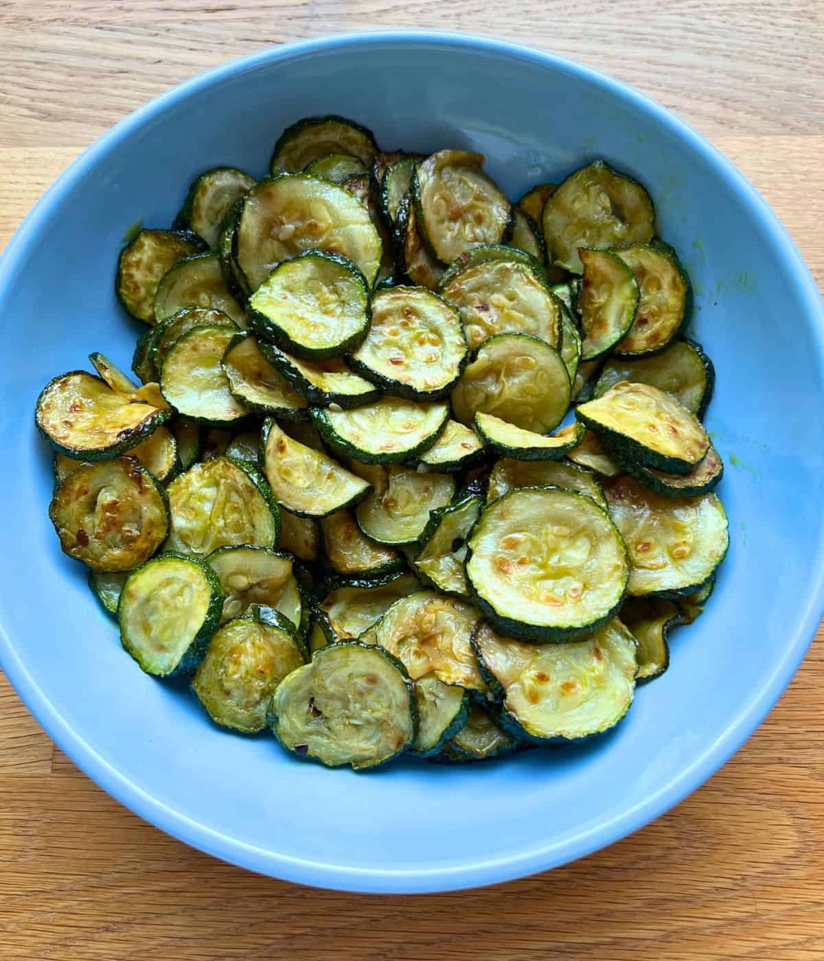 Fried slices of zucchini in a blue bowl.