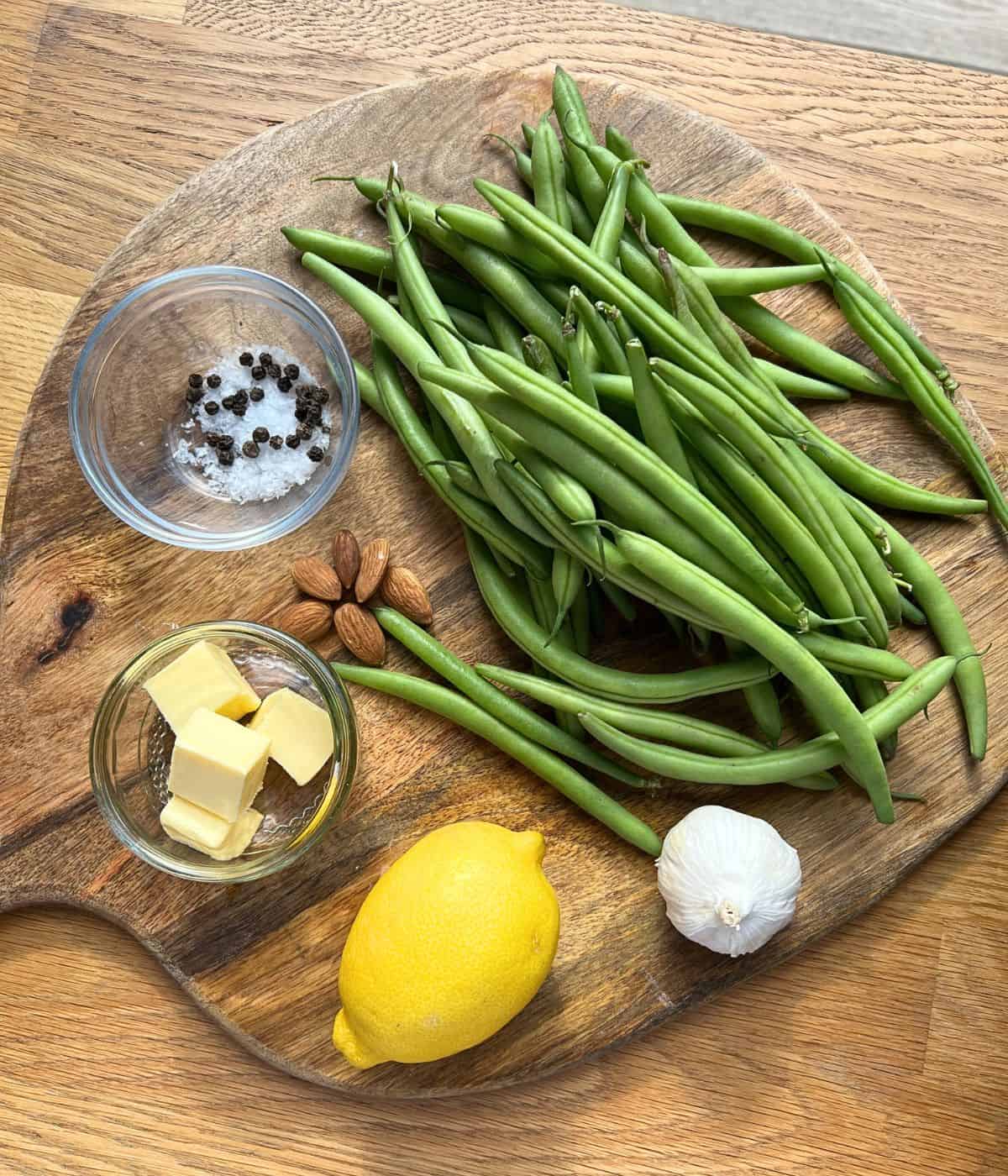 Ingredients for green beans with garlic on a wood board.