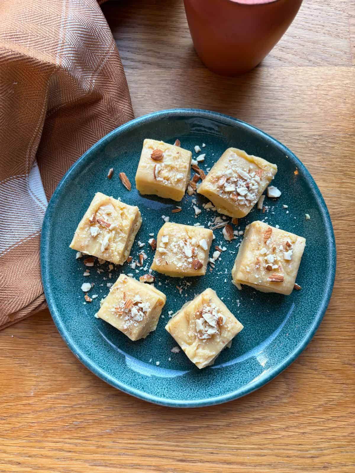 Barfi squares on green plate.