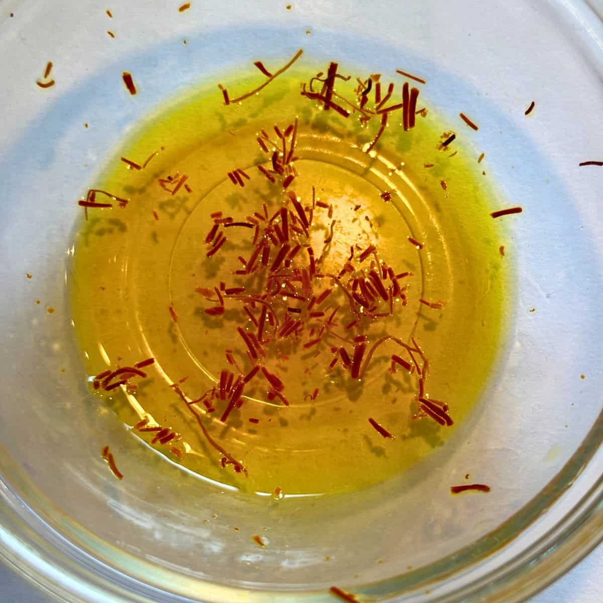 Blooming saffron in water in small glass bowl.
